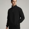 Model wearing a Black Frontier Falcon quarter-zip sweatshirt with a clean, minimalist design.