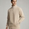 Model wearing a Beige Frontier Falcon quarter-zip sweatshirt with a clean, minimalist design.